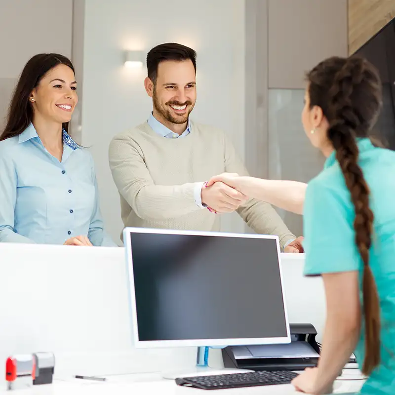 Patients being welcomed by a receptionist at Greater Ohio Oral & Facial Surgery. 